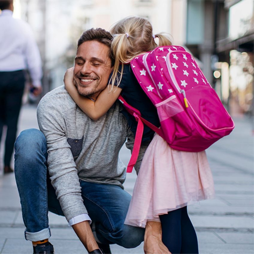 Vater und Tochter mit Schulranzen