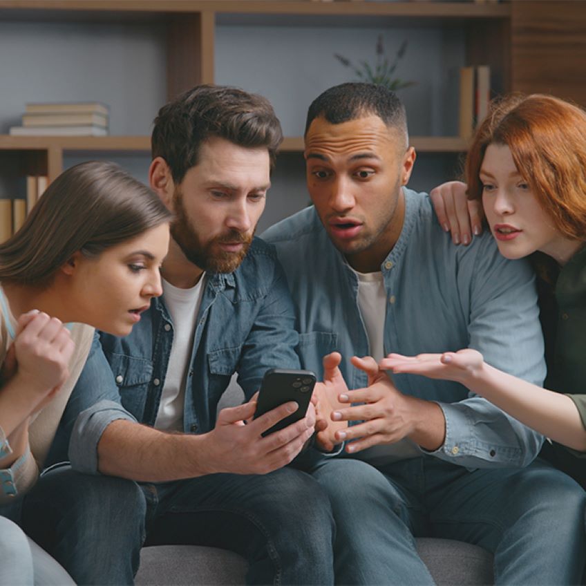 4 Menschen schauen auf ein Handy